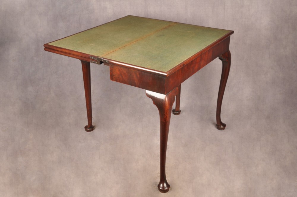 An 18th-century mahogany triple-top card table resting on four cabriole legs with pad feet. View IX
