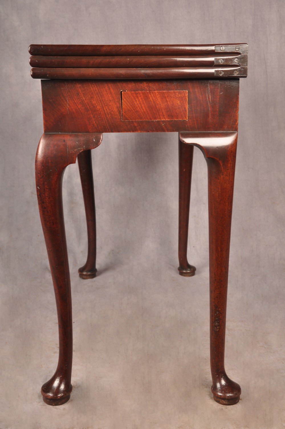 An 18th-century mahogany triple-top card table resting on four cabriole legs with pad feet. View XV