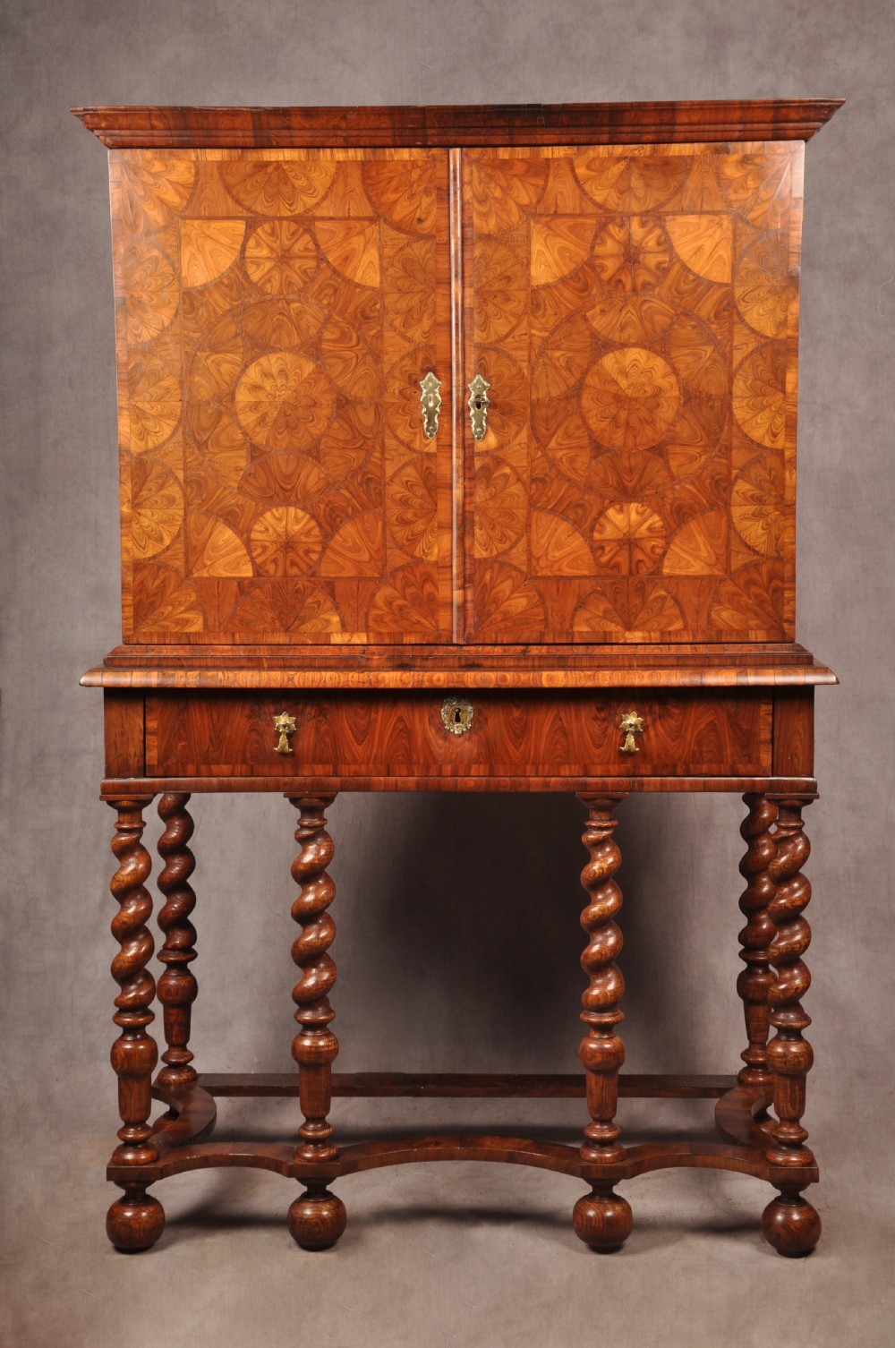 A seventeenth-century kingwood cabinet on stand featuring geometric oyster parquetry doors, a single frieze drawer, six barley twist legs, and a shaped stretcher. View II