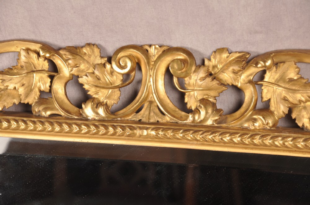 An early nineteenth-century rectangular wall mirror set within a deeply carved Florentine giltwood frame featuring openwork foliage, scrolls, and a beaded inner edge. View III