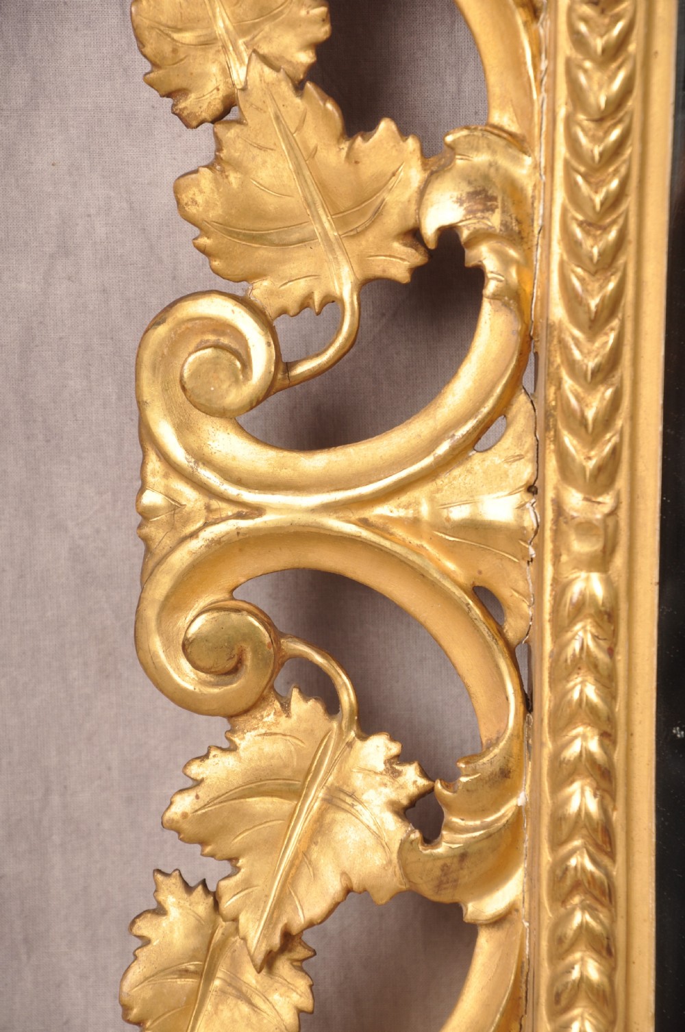 An early nineteenth-century rectangular wall mirror set within a deeply carved Florentine giltwood frame featuring openwork foliage, scrolls, and a beaded inner edge. View IV