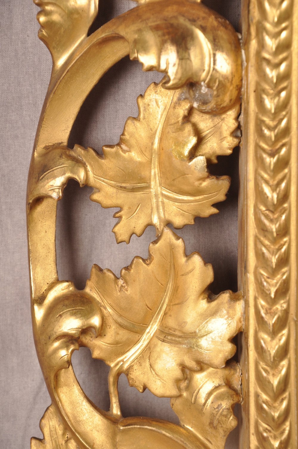 An early nineteenth-century rectangular wall mirror set within a deeply carved Florentine giltwood frame featuring openwork foliage, scrolls, and a beaded inner edge. View V