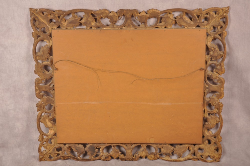 An early nineteenth-century rectangular wall mirror set within a deeply carved Florentine giltwood frame featuring openwork foliage, scrolls, and a beaded inner edge. View VIII