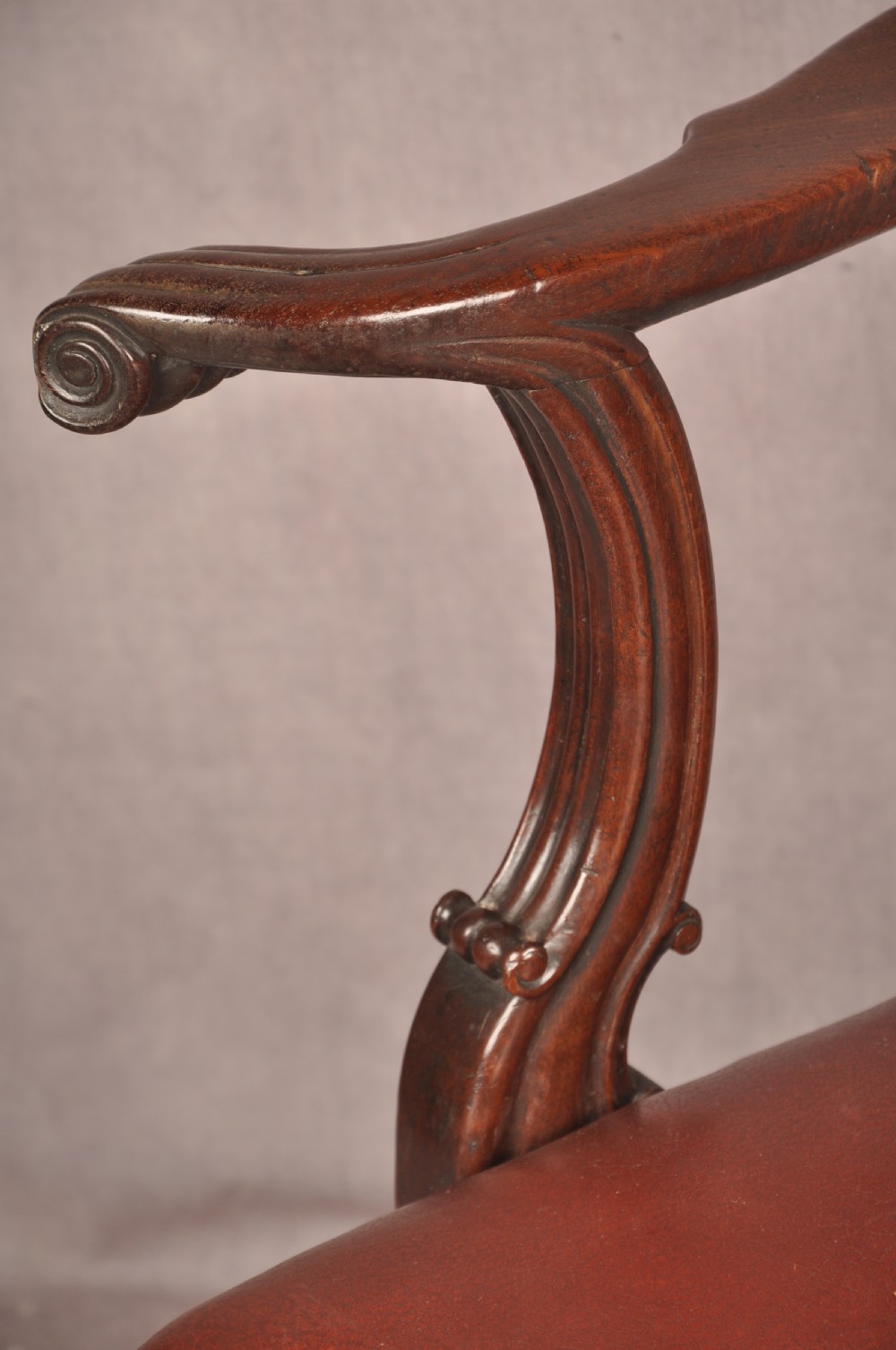 An 18th-century Chippendale mahogany armchair featuring an intricately carved Gothic tracery back splat, out-swept armrests, a brown leather seat, and square legs. View IV