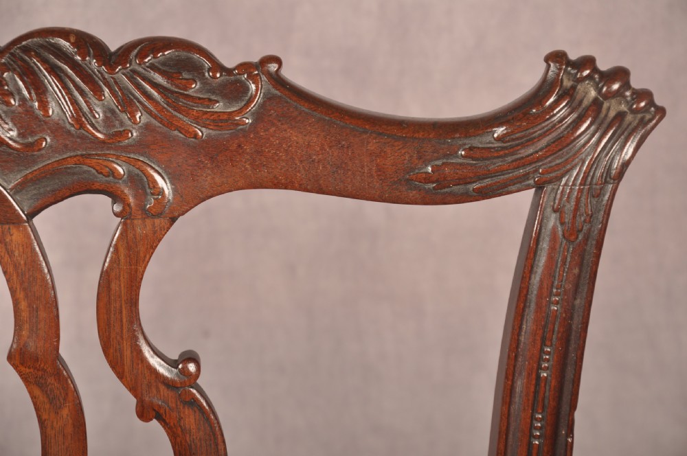An 18th-century Chippendale mahogany armchair featuring an intricately carved Gothic tracery back splat, out-swept armrests, a brown leather seat, and square legs. View VII