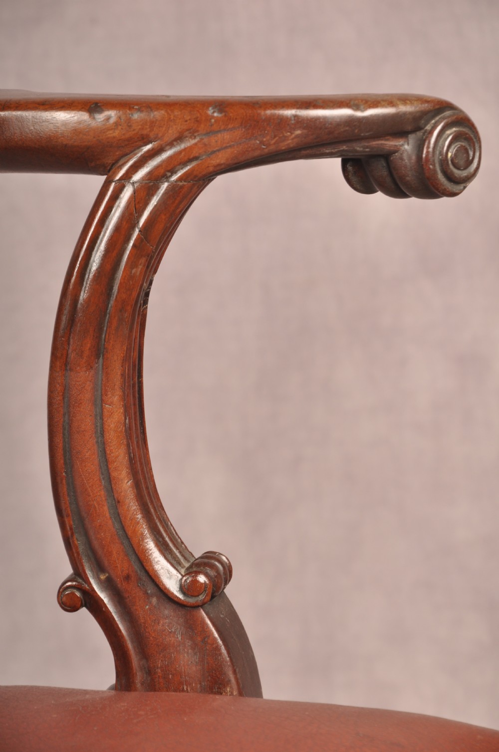 An 18th-century Chippendale mahogany armchair featuring an intricately carved Gothic tracery back splat, out-swept armrests, a brown leather seat, and square legs. View VIII