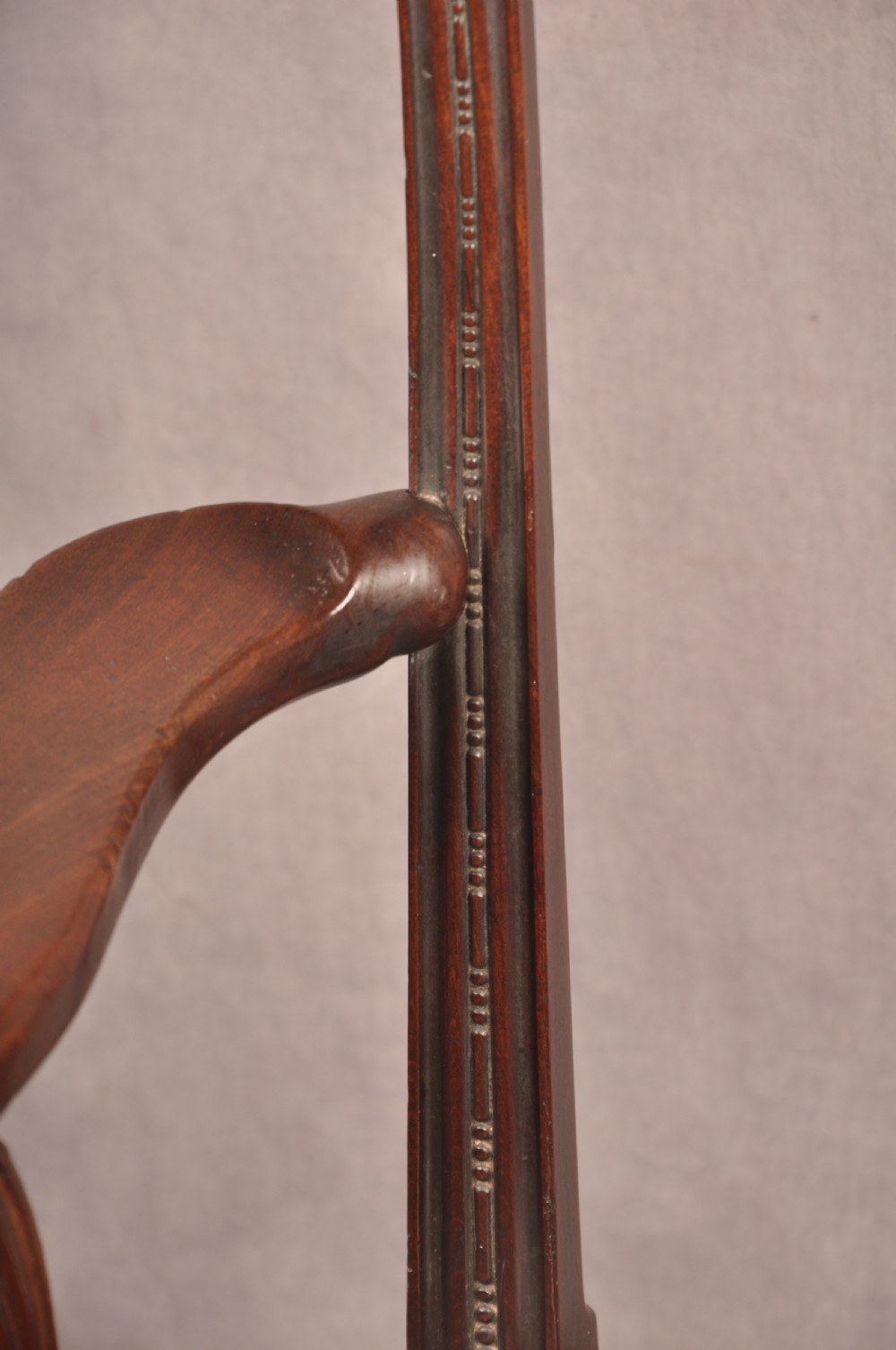 An 18th-century Chippendale mahogany armchair featuring an intricately carved Gothic tracery back splat, out-swept armrests, a brown leather seat, and square legs. View X