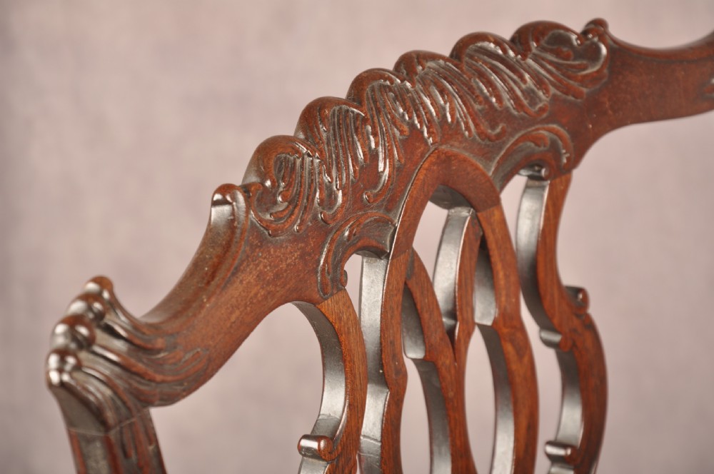 An 18th-century Chippendale mahogany armchair featuring an intricately carved Gothic tracery back splat, out-swept armrests, a brown leather seat, and square legs. View XI