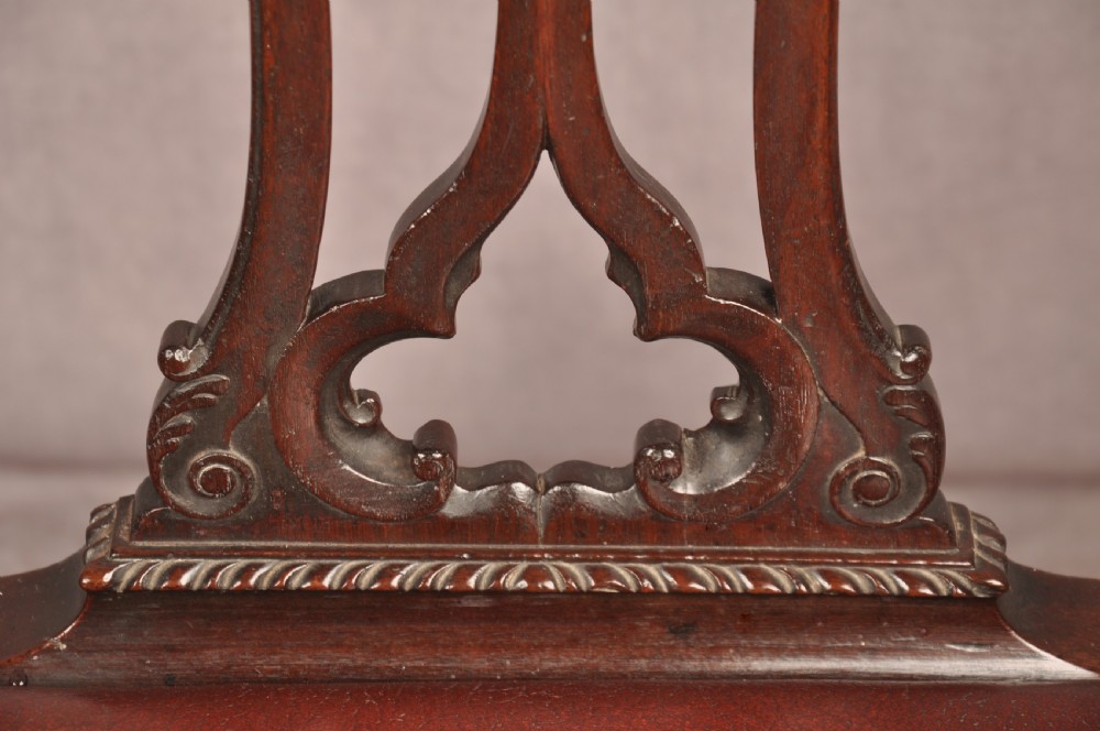 An 18th-century Chippendale mahogany armchair featuring an intricately carved Gothic tracery back splat, out-swept armrests, a brown leather seat, and square legs. View XII