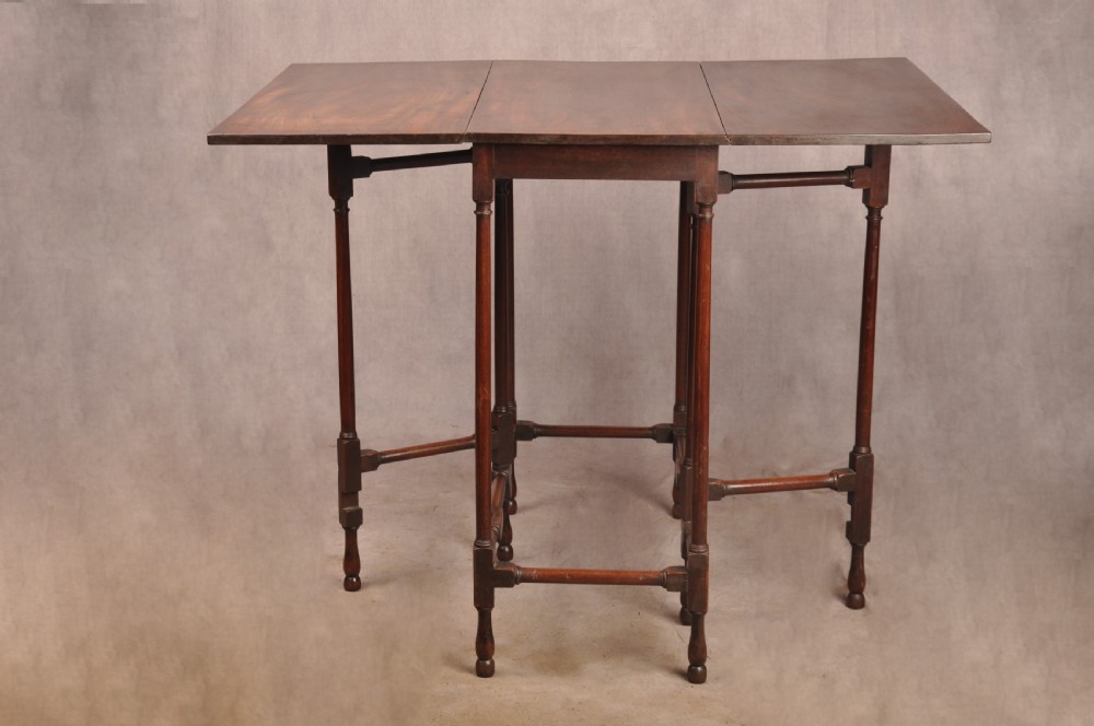 An 18th-century mahogany drop-leaf spider table featuring slender turned legs, cross stretchers, and two fold-out side flaps. View V