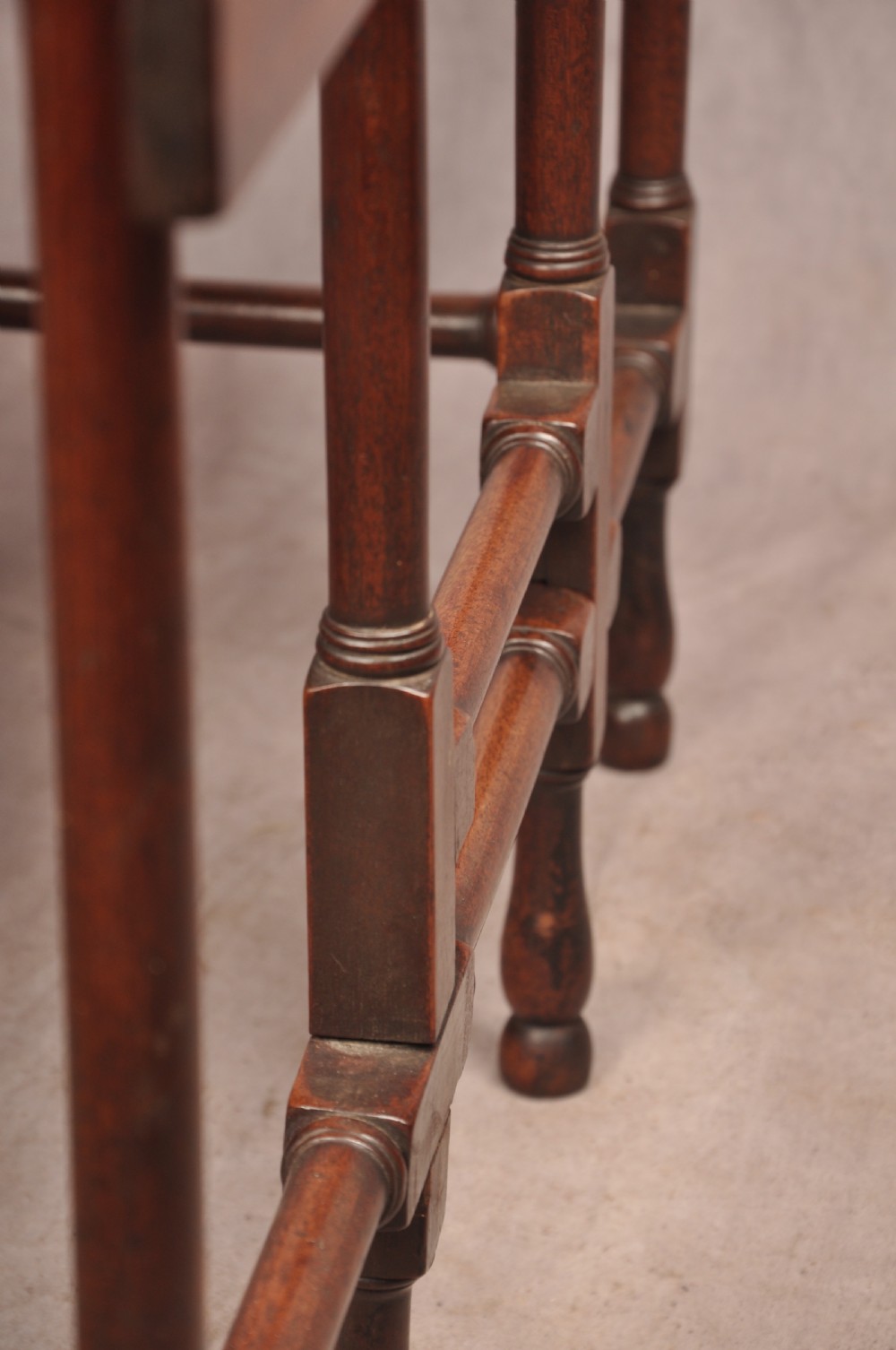 An 18th-century mahogany drop-leaf spider table featuring slender turned legs, cross stretchers, and two fold-out side flaps. View IX