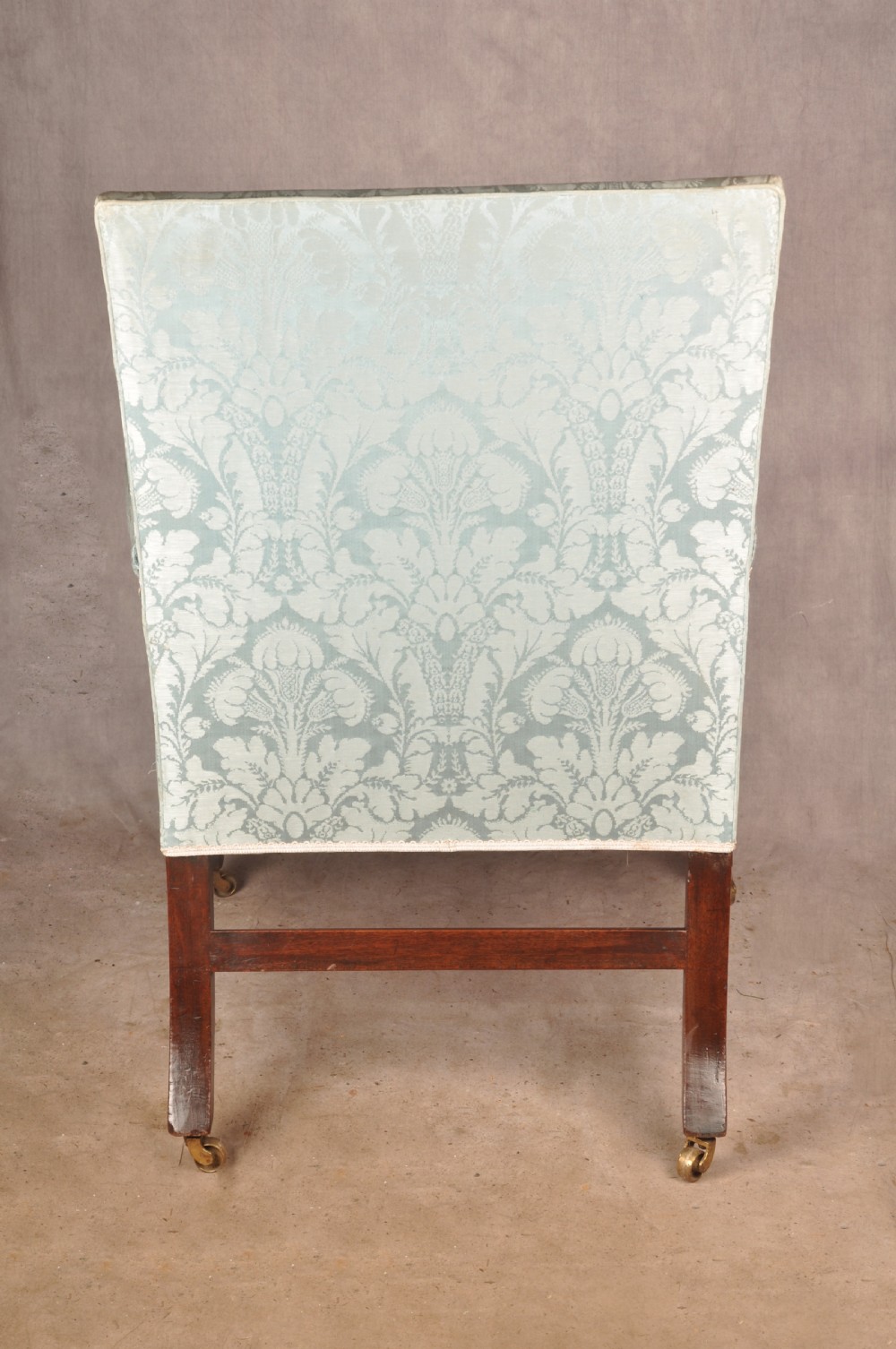 An eighteenth-century mahogany Gainsborough library armchair upholstered in pale blue damask fabric with brass castors. View IV
