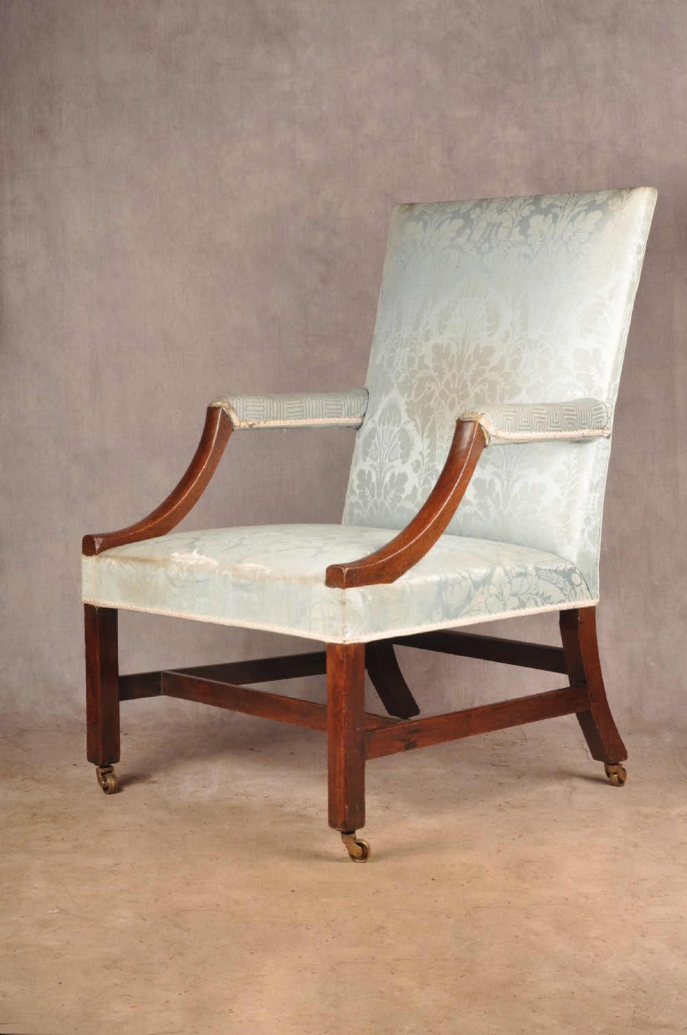 An eighteenth-century mahogany Gainsborough library armchair upholstered in pale blue damask fabric with brass castors. View VII