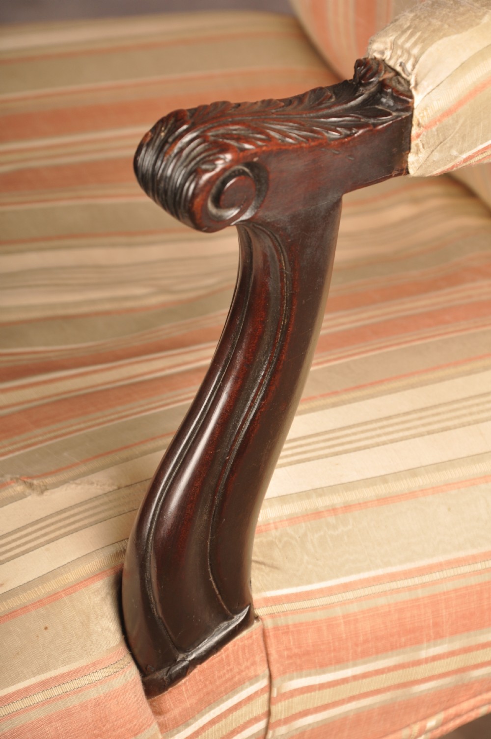 An 18th-century mahogany library chair upholstered in striped pink and cream fabric, featuring hand-carved cabriole front legs with ball-and-claw feet. View VI