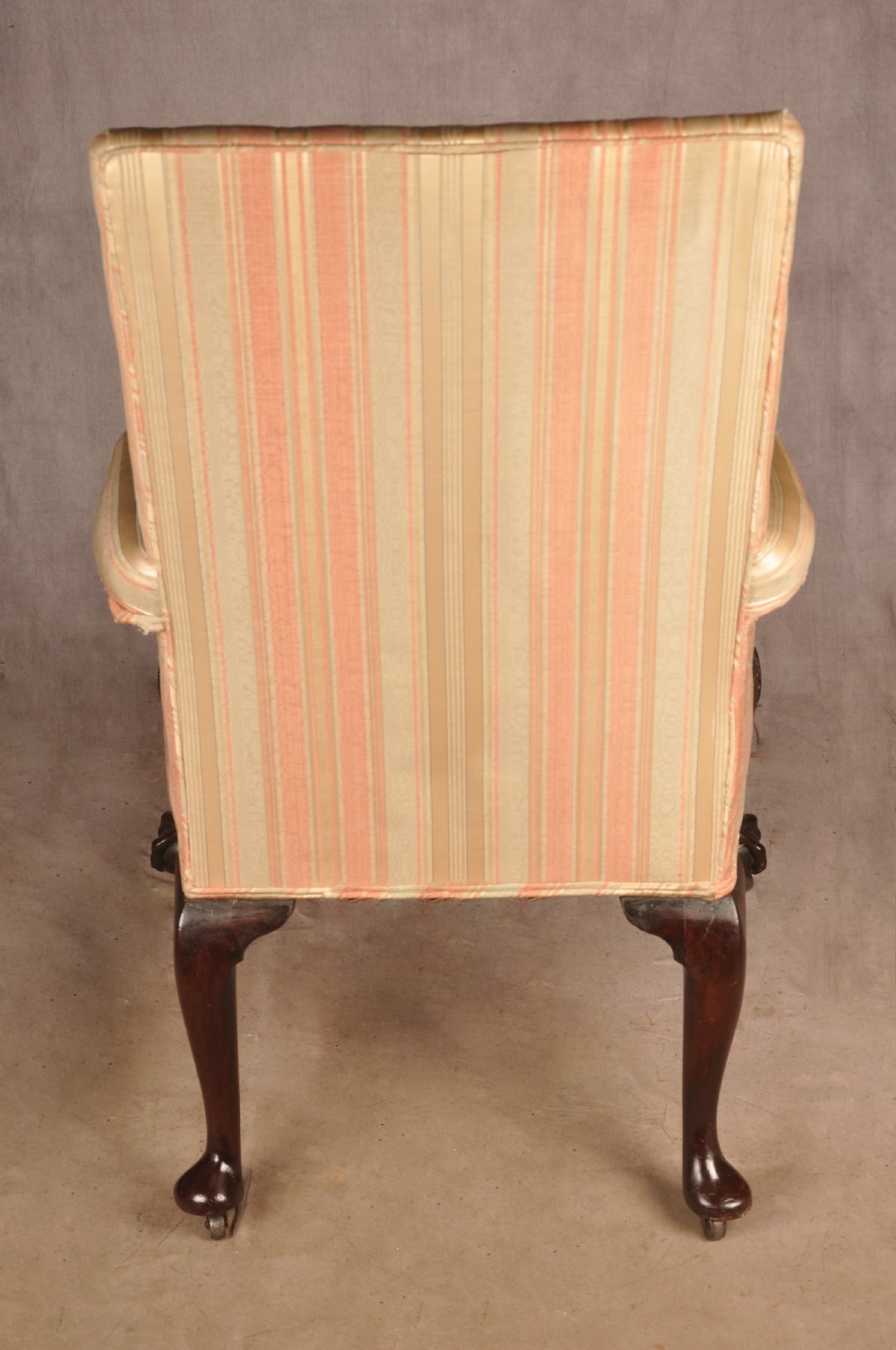 An 18th-century mahogany library chair upholstered in striped pink and cream fabric, featuring hand-carved cabriole front legs with ball-and-claw feet. View X