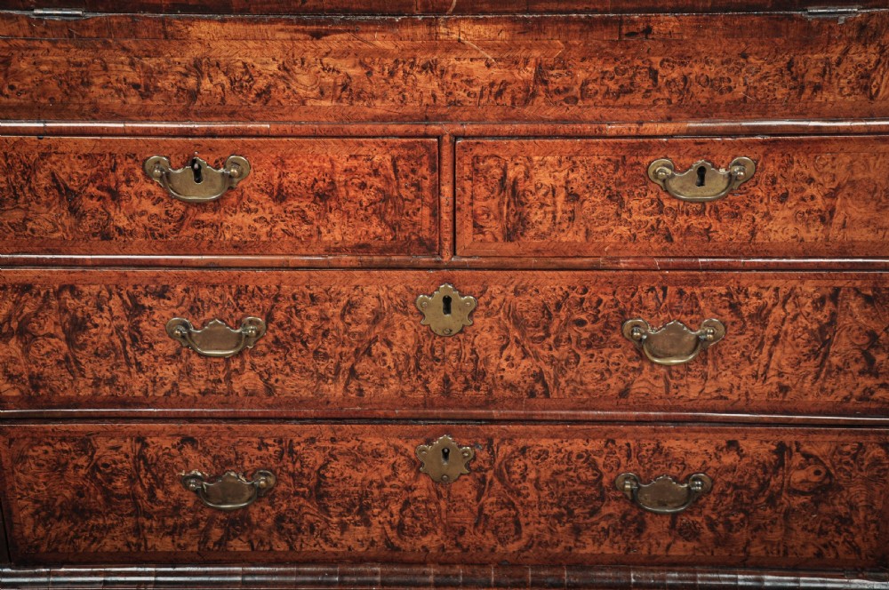 A late 17th-century slant-front bureau featuring highly figured mulberry veneer, brass drop handles, keyhole escutcheons, and four drawers resting on bracket feet. View II