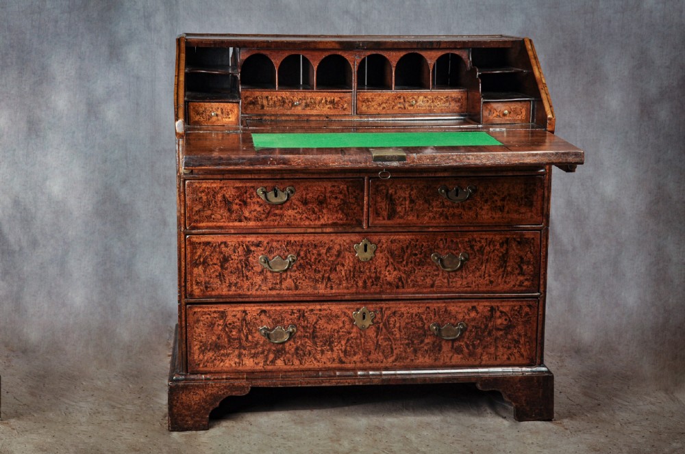 A late 17th-century slant-front bureau featuring highly figured mulberry veneer, brass drop handles, keyhole escutcheons, and four drawers resting on bracket feet. View III