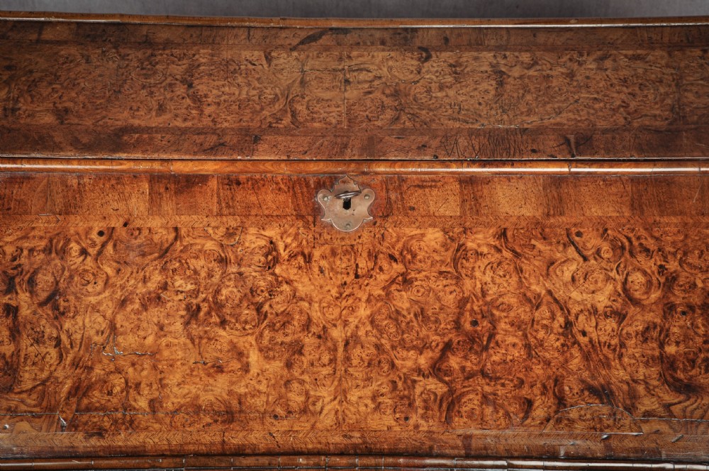 A late 17th-century slant-front bureau featuring highly figured mulberry veneer, brass drop handles, keyhole escutcheons, and four drawers resting on bracket feet. View IX