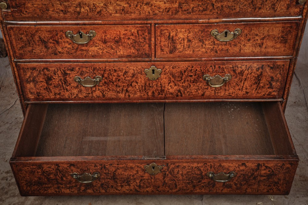 A late 17th-century slant-front bureau featuring highly figured mulberry veneer, brass drop handles, keyhole escutcheons, and four drawers resting on bracket feet. View XI