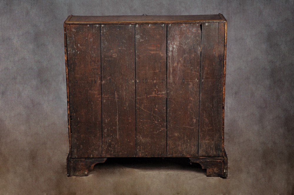 A late 17th-century slant-front bureau featuring highly figured mulberry veneer, brass drop handles, keyhole escutcheons, and four drawers resting on bracket feet. View XV