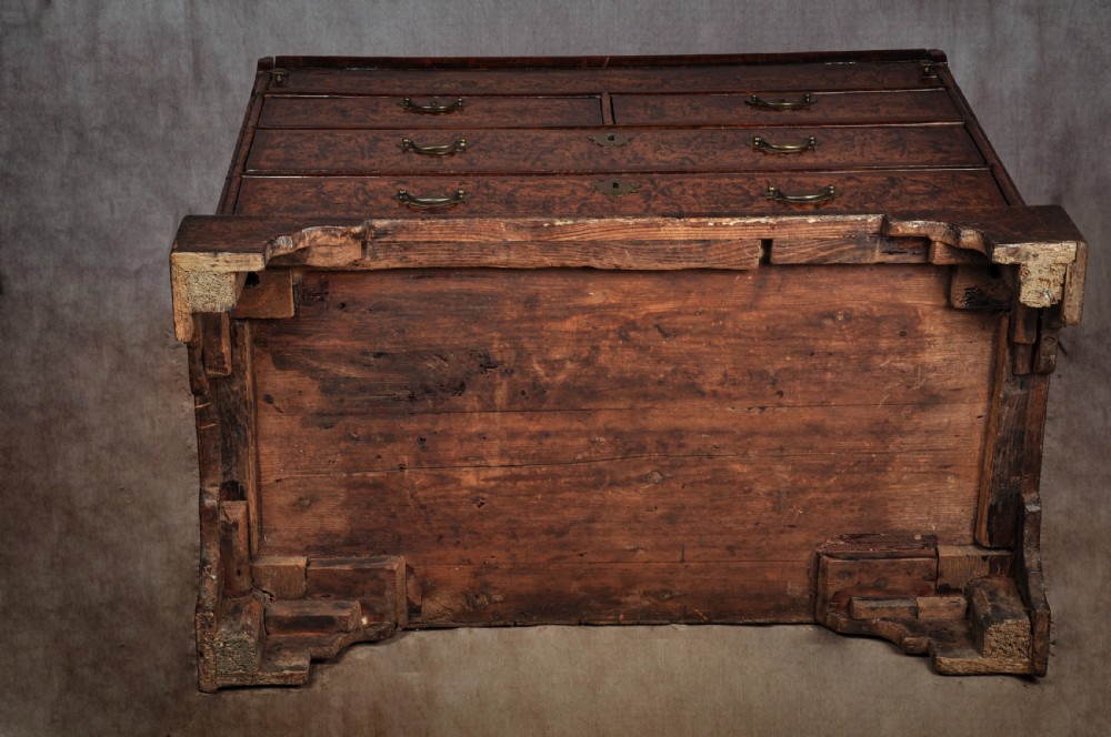 A late 17th-century slant-front bureau featuring highly figured mulberry veneer, brass drop handles, keyhole escutcheons, and four drawers resting on bracket feet. View XVI