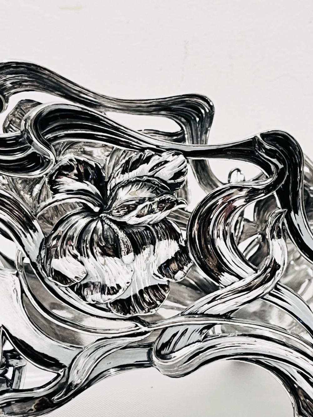 An Art Nouveau silver-plated wine wagon shaped like a stylized wheelbarrow with intricate botanical openwork and flowing organic curves. View II