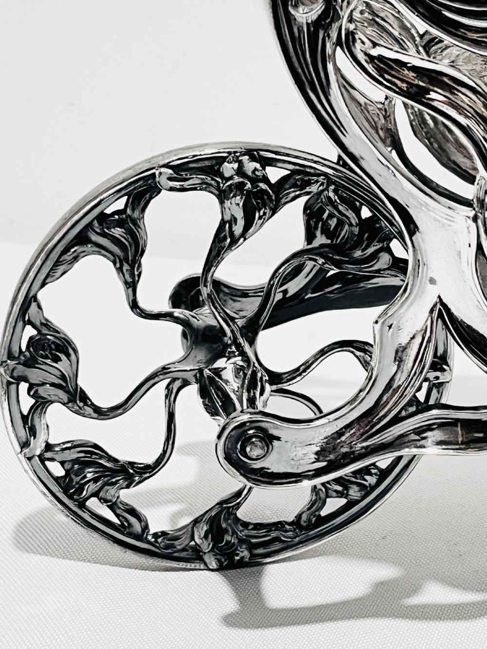 An Art Nouveau silver-plated wine wagon shaped like a stylized wheelbarrow with intricate botanical openwork and flowing organic curves. View V