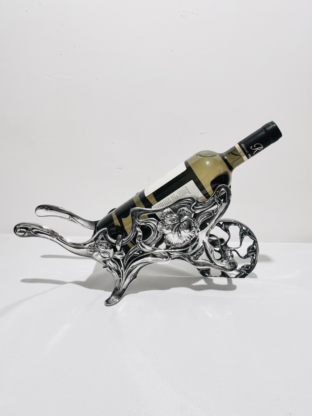 An Art Nouveau silver-plated wine wagon shaped like a stylized wheelbarrow with intricate botanical openwork and flowing organic curves. View VIII
