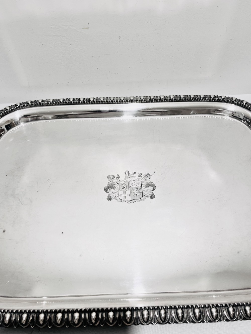 A rectangular silver-plated tray featuring ornate cast acanthus handles, a gadrooned rim, and an engraved heraldic coat of arms at the centre. View IV