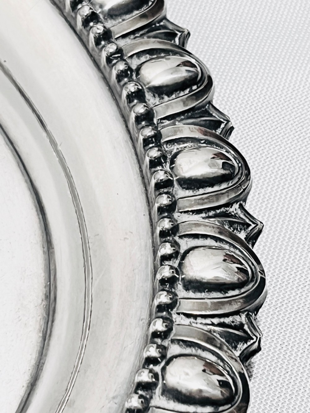 A rectangular silver-plated tray featuring ornate cast acanthus handles, a gadrooned rim, and an engraved heraldic coat of arms at the centre. View V