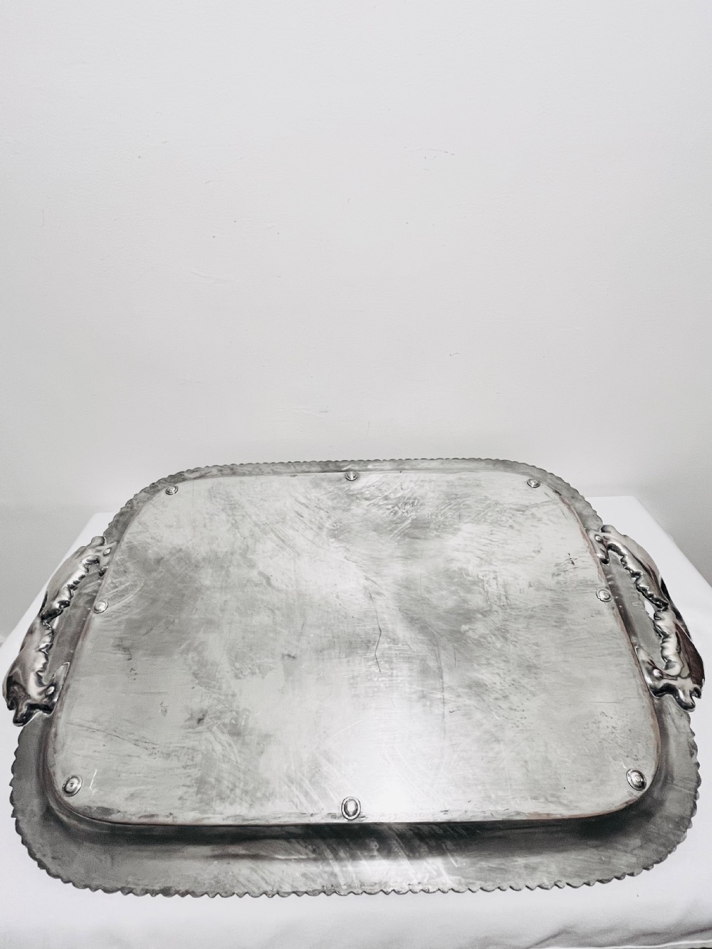 A rectangular silver-plated tray featuring ornate cast acanthus handles, a gadrooned rim, and an engraved heraldic coat of arms at the centre. View VII
