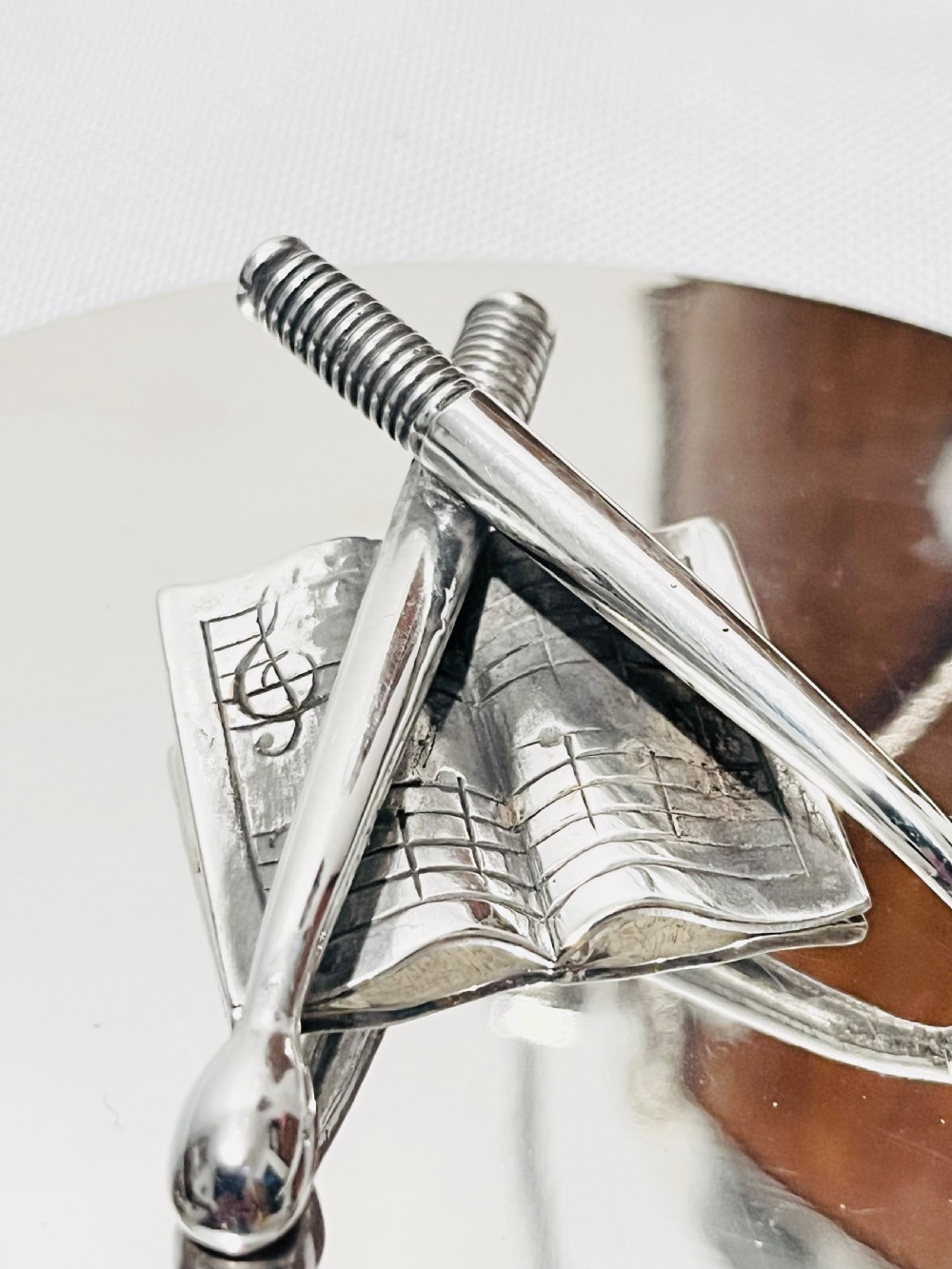 A drum-shaped antique oak biscuit box featuring silver-plated rims, rope cord detail, crossed drumstick lid finial, and a silver swing handle. View III