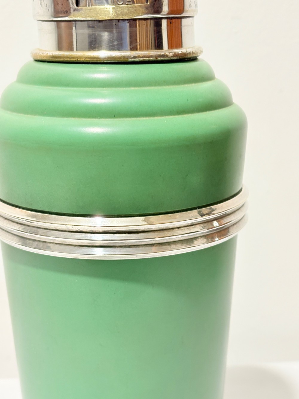 An Art Deco Master Incolor cocktail shaker featuring a green Bakelite body with silver-plated trim and a rotating recipe window cap. View II