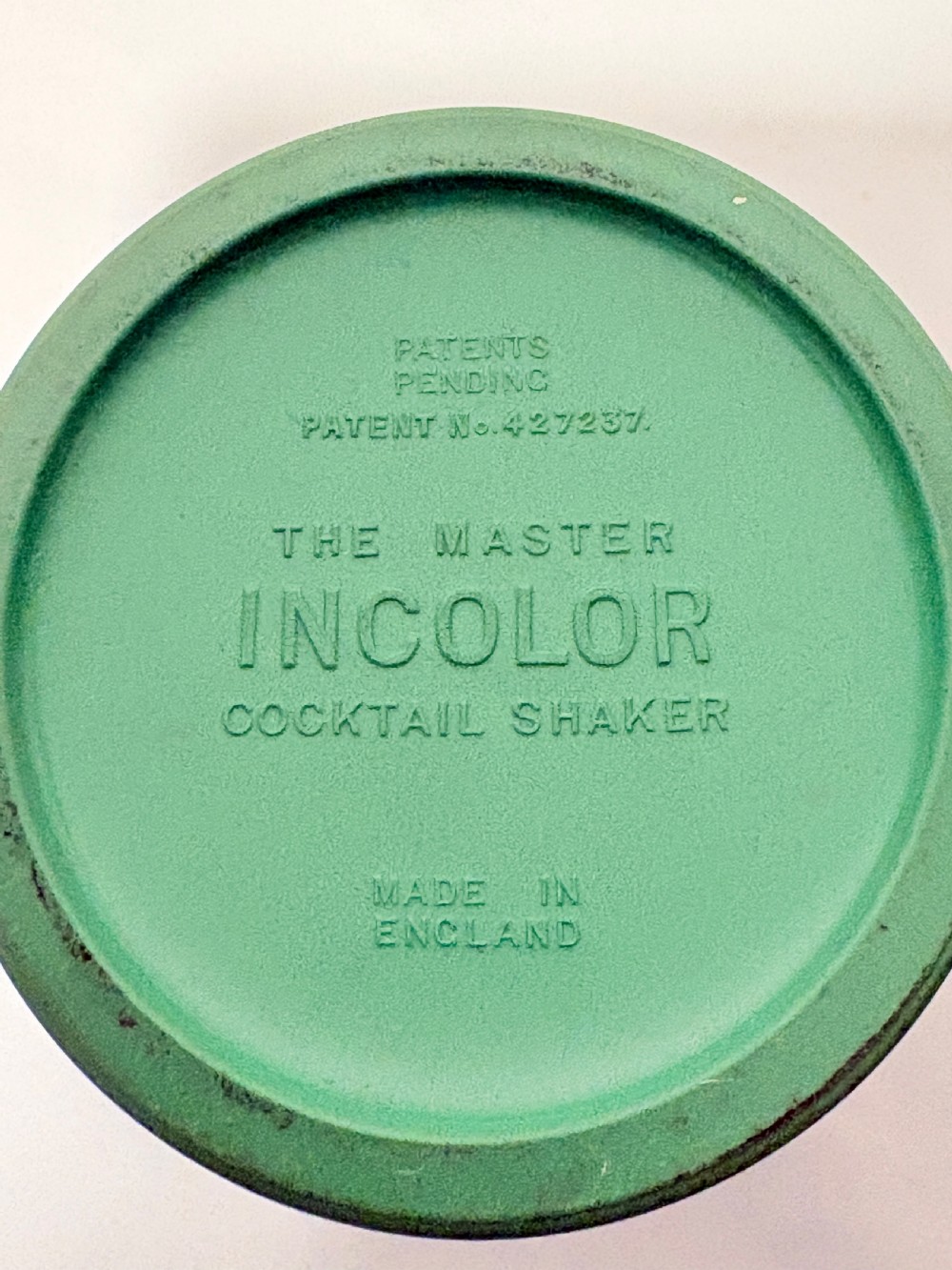 An Art Deco Master Incolor cocktail shaker featuring a green Bakelite body with silver-plated trim and a rotating recipe window cap. View VII