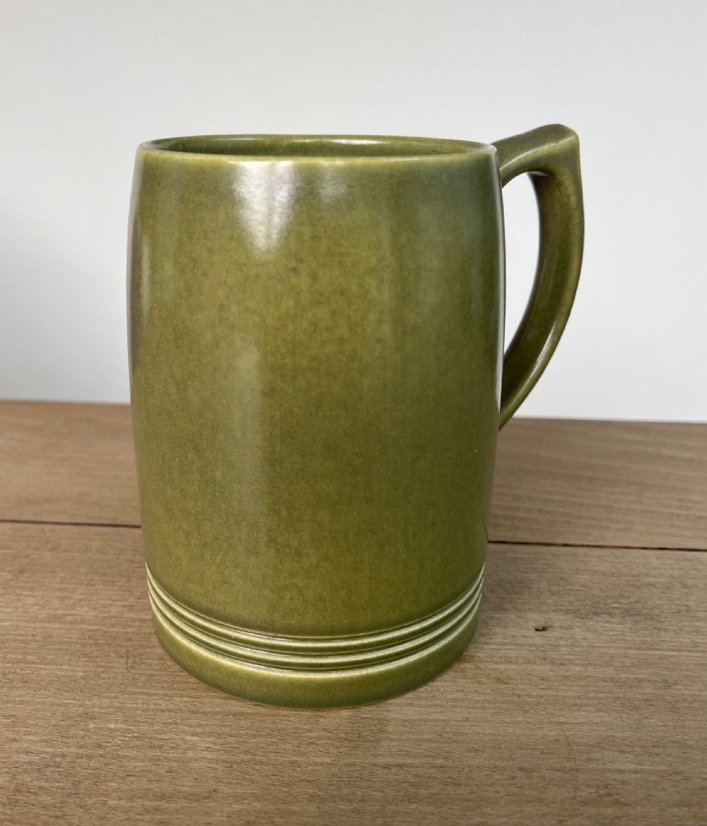 A green glazed Art Deco ceramic tankard featuring a geometric angular handle and subtle concentric ribbed detail around the base. View III