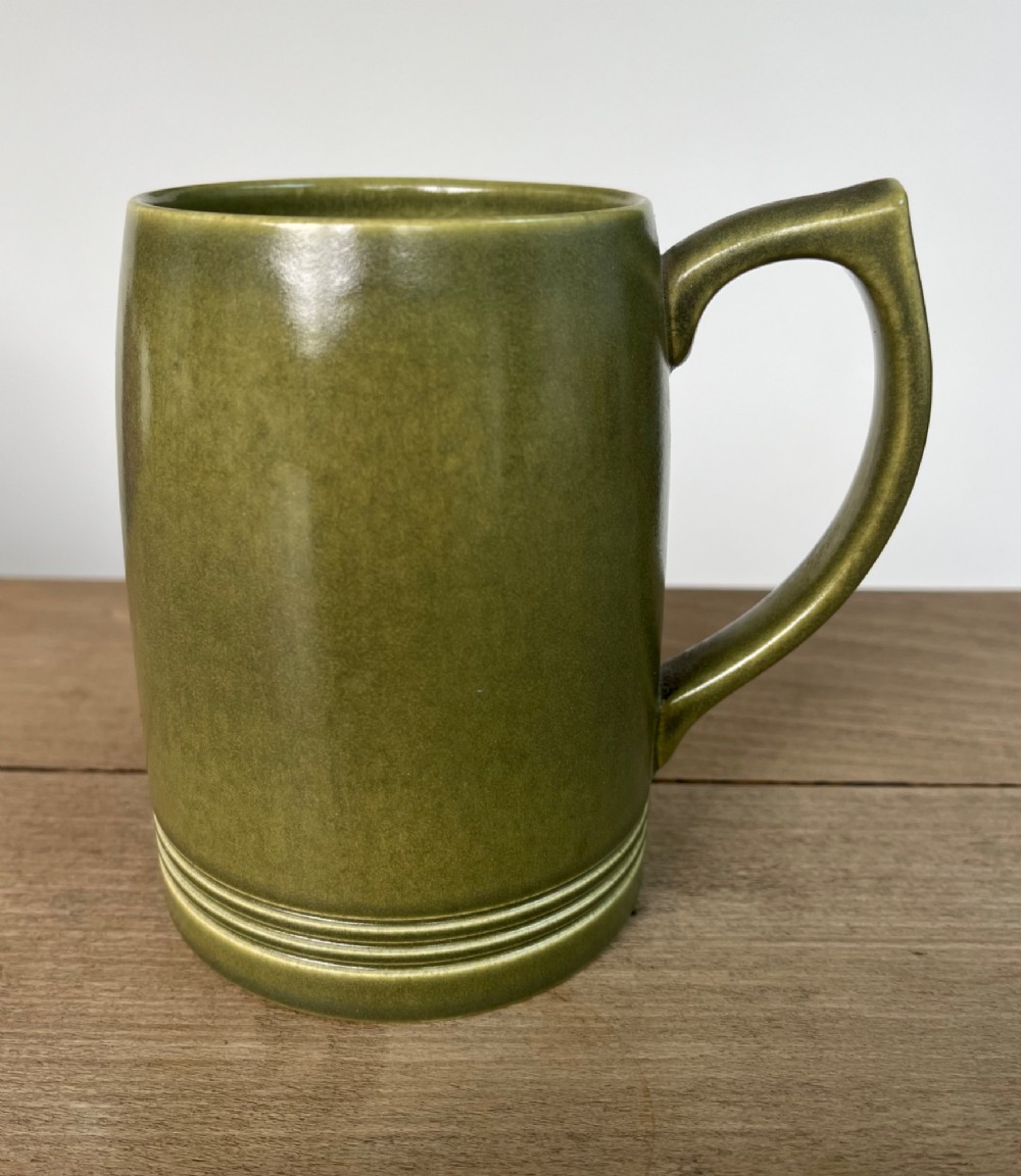 A green glazed Art Deco ceramic tankard featuring a geometric angular handle and subtle concentric ribbed detail around the base. View IV