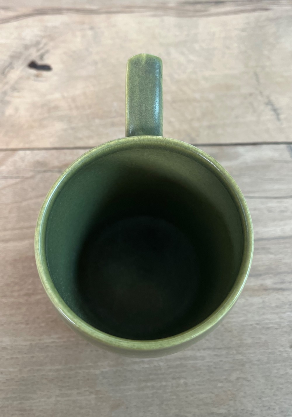 A green glazed Art Deco ceramic tankard featuring a geometric angular handle and subtle concentric ribbed detail around the base. View V