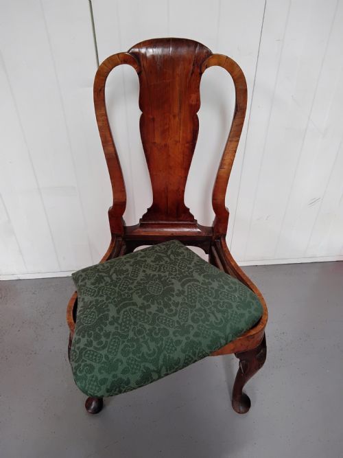fig 2. An antique Queen Anne walnut side chair featuring a vase-shaped splat back, green patterned drop-in seat, and carved cabriole legs with pad feet.