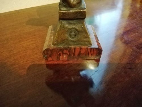 fig 1. A patinated bronze bust depicting a female figure wearing a headscarf, titled Saida, mounted on a red marble base.