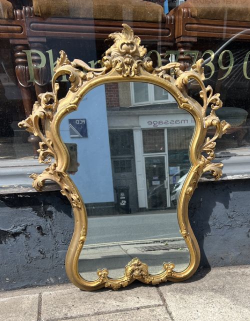 A GILDED ROCOCO STYLE WALL MIRROR