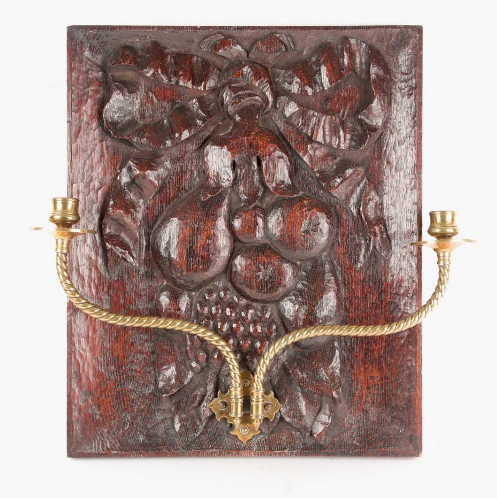 Carved oak panel with large pair of brass candle sconces 