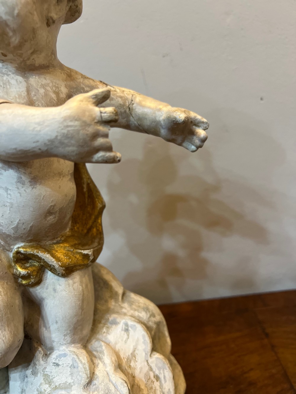 A pair of 18th-century carved wood polychrome putti featuring painted off-white figures with gilded wings and drapery, resting upon carved cloud bases. View XI
