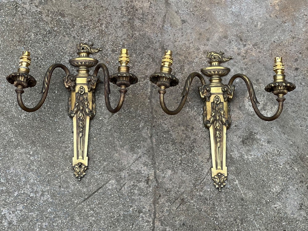 A pair of Edwardian cast brass twin-arm wall lights designed in the Neoclassical Adam style with urn finials and tapered backplates. View II