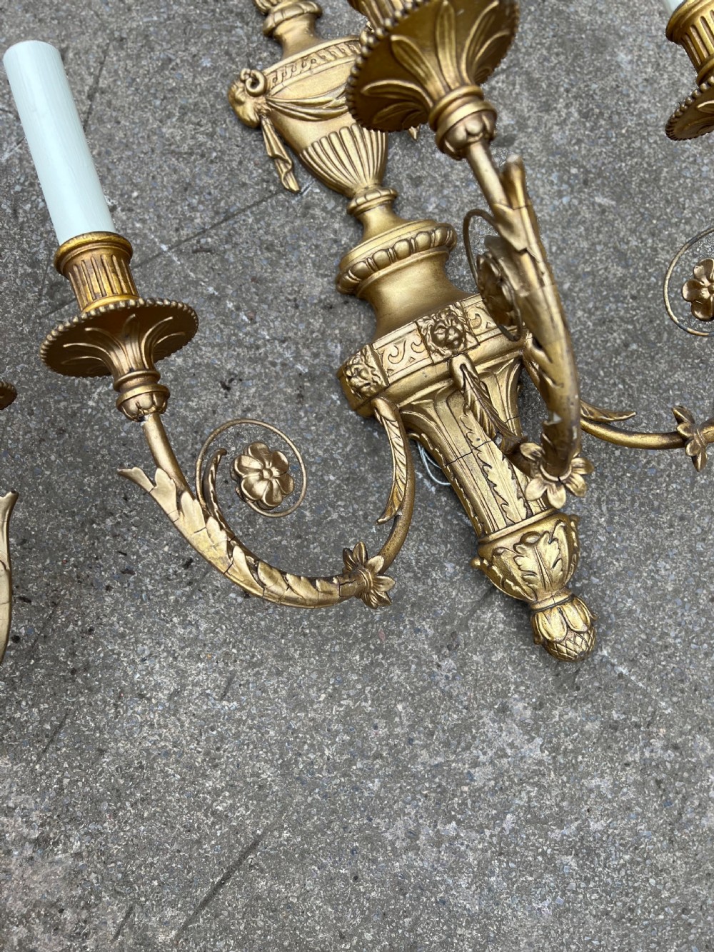 A pair of three-arm Neoclassical style giltwood and gesso wall sconces featuring urn backplates and foliage scrollwork. View VI