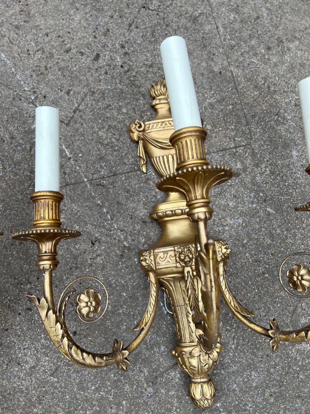 A pair of three-arm Neoclassical style giltwood and gesso wall sconces featuring urn backplates and foliage scrollwork. View VIII