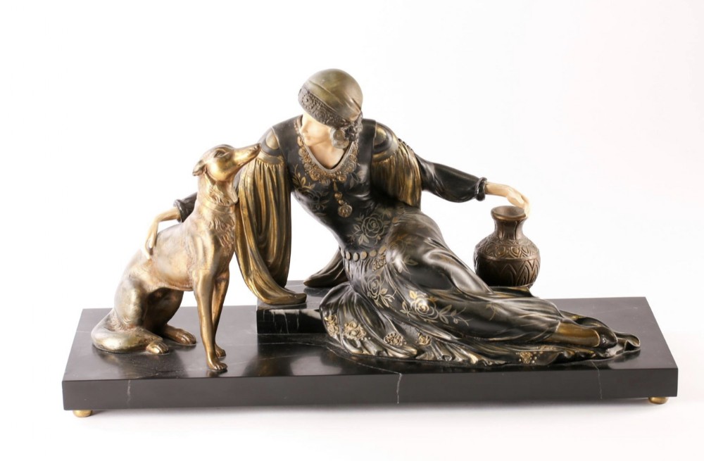 An Art Deco figure group by mennivelle C1920-30 depicting a woman seated with her dog  