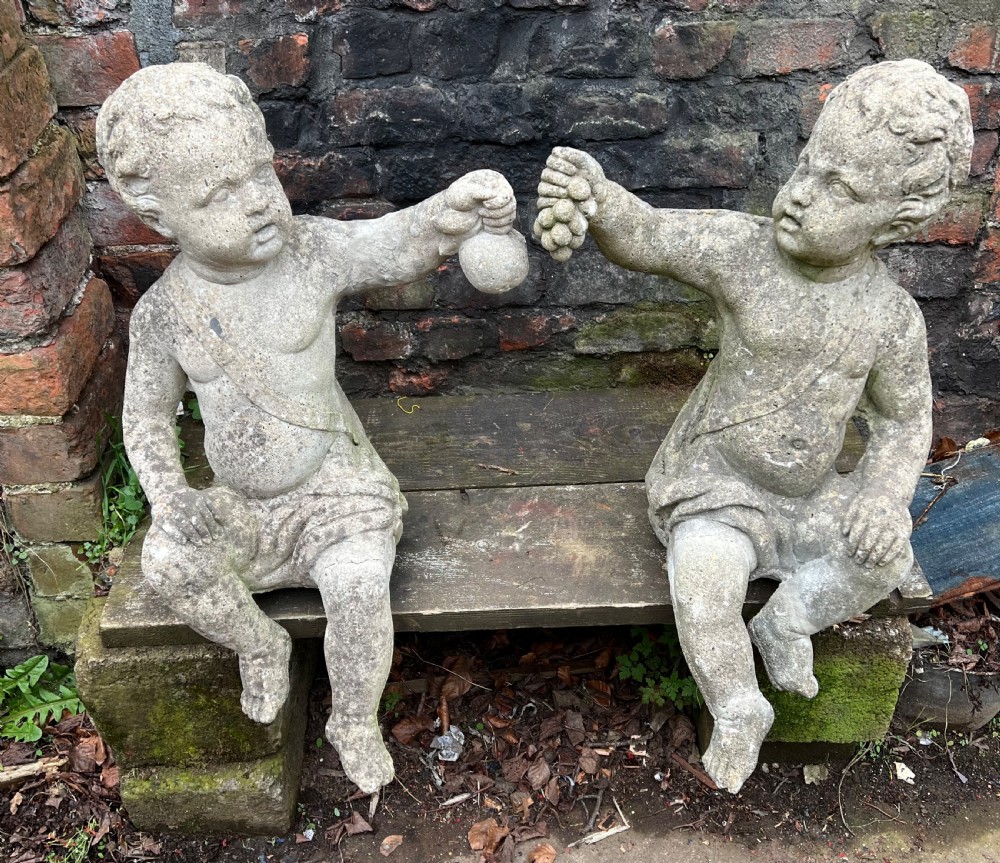 Large pair of putti holding aloft fruit 