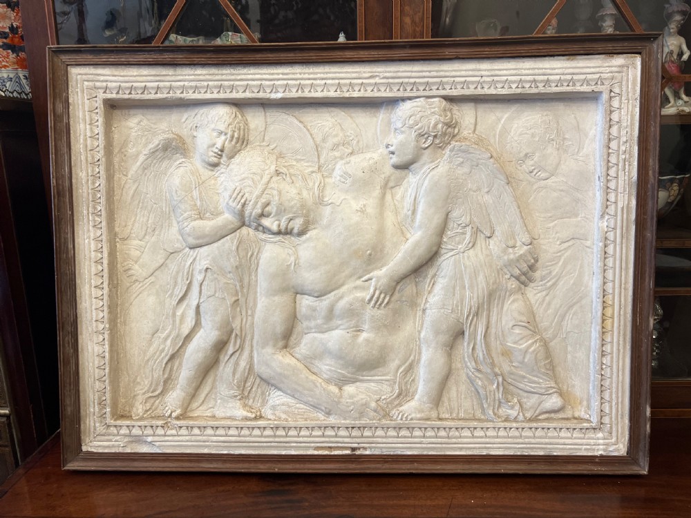 An off-white 19th-century plaster bas-relief panel depicting Christ supported by angels, framed within an inner egg-and-dart moulding and dark timber outer frame. View II