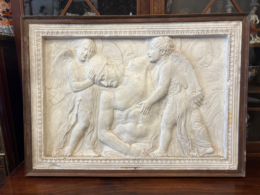 An off-white 19th-century plaster bas-relief panel depicting Christ supported by angels, framed within an inner egg-and-dart moulding and dark timber outer frame. View III