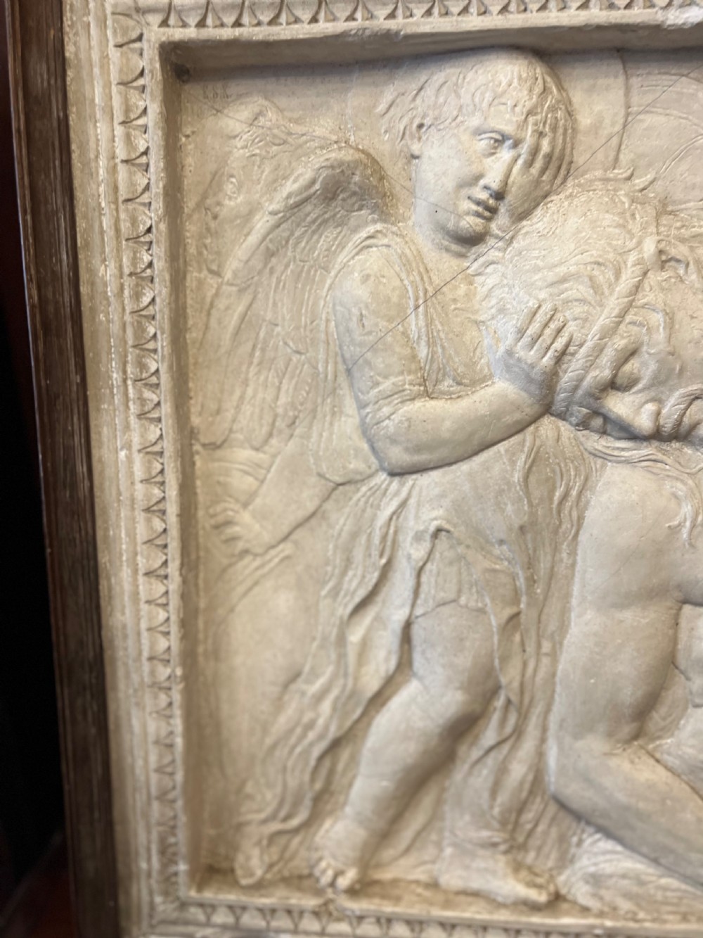 An off-white 19th-century plaster bas-relief panel depicting Christ supported by angels, framed within an inner egg-and-dart moulding and dark timber outer frame. View VI